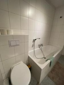 a bathroom with a toilet and a bath tub at GoldMol Nuremberg Old Town in Nuremberg