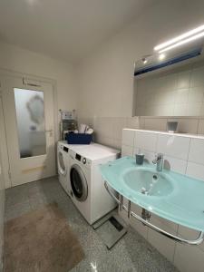 a bathroom with a washing machine and a sink at Vintage Apartment Nuremberg Old Town in Nuremberg