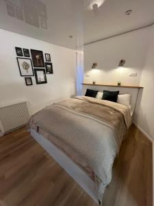 - une chambre avec un grand lit et des photos sur le mur dans l'établissement Terrassenpark Apartments (Premium Rooms), à Sasbachwalden