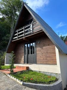una pequeña casa de madera con techo de gambrel en Recanto da Vila - Chalé 01, en Governador Celso Ramos