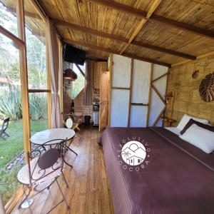 a bedroom in a tree house with a bed and a table at Exclusivo Cocora con Jacuzzi Salento Quindio in Salento