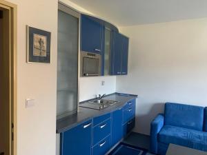 a blue kitchen with a sink and a blue couch at Ubytování u sjezdovky Tanvaldský Špičák II. s garáží in Albrechtice v Jizerských horách