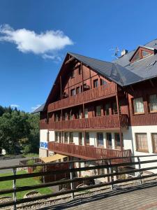 un gran edificio de madera con un balcón en la parte delantera en Ubytování u sjezdovky Tanvaldský Špičák II. s garáží en Albrechtice v Jizerských horách