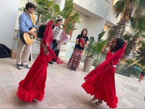 a woman in a red dress playing a instrument at Villaggio Poseidone Beach Resort - Hotel in Torre San Giovanni Ugento +31 photos