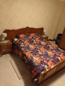 1 cama con edredón de flores en un dormitorio en The best known village of Belgium, en Puurs