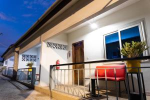 a balcony of a house with two red chairs at Village Francophone Hotel in Kasoa