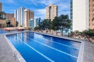 a swimming pool in a city with tall buildings at Don Miguel 4-F Apartment Levante Beach in Benidorm