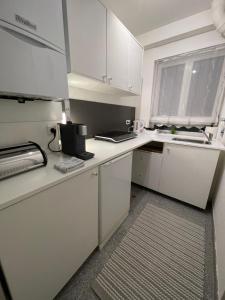 a white kitchen with white cabinets and a window at Vintage Apartment Nuremberg Old Town in Nuremberg
