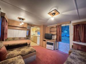 a living room with two beds and a tv at Your Caravan Hel in Hel