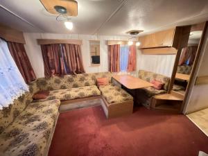 a living room with a couch and a table at Your Caravan Hel in Hel