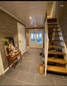 a room with a staircase and a table and a stair case at Koselig, nyere hytte til leie in Stranda