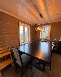 a dining room with a large wooden table and chairs at Koselig, nyere hytte til leie in Stranda