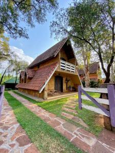 a building with a gambrel roof and a fence at Mirágua Refugios Pousada in Brotas