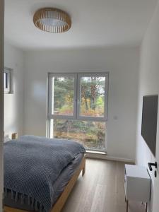 1 dormitorio con cama y ventana grande en Modernes Ferienhaus in der Nähe vom Scharmützelsee, en Wendisch Rietz