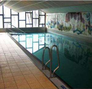 a swimming pool with stairs in a building at Seeapartment am Ossiacher See am Fuße der Gerlitzen in Stiegl