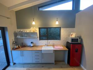a kitchen with a sink and a microwave at Am Ufer 14 in Windhoek