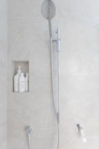 a shower with a shower head in a bathroom at Queenstown Modern Studio at Arthurs Point in Queenstown