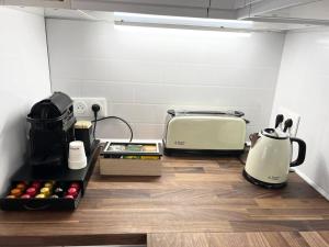 a kitchen with a toaster and a toaster and a toaster at House climatisée & parking à 15 minutes de Paris in Bagneux