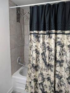 La salle de bains est pourvue d'une douche et d'un rideau de douche. dans l'établissement Cozy basement apartment in the heart of Oakville, à Oakville