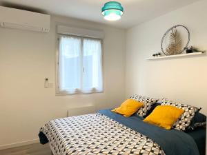 - une chambre avec un lit doté d'oreillers jaunes et d'une fenêtre dans l'établissement House climatisée & parking à 15 minutes de Paris, à Bagneux