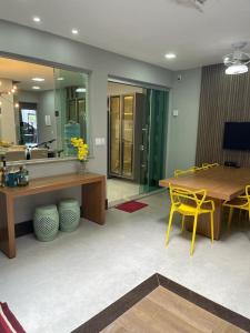 uma sala de estar com uma mesa e uma cadeira amarela em Cidade Nova, Gov. Valadares em Governador Valadares