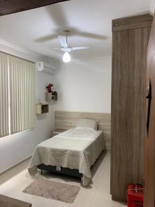 a bedroom with a bed and a ceiling fan at Cidade Nova, Gov. Valadares in Governador Valadares