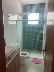 a bathroom with a toilet and a glass shower at Cidade Nova, Gov. Valadares in Governador Valadares