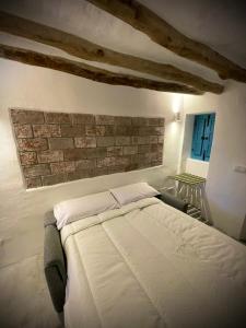 a bed in a bedroom with a brick wall at CASA MÚA in Frigiliana