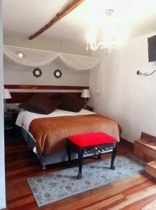 a bedroom with a bed with a red bench at Kori Gems Inn in Cusco