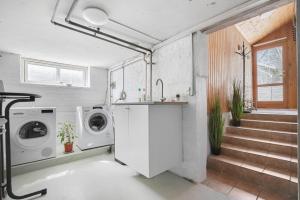 a kitchen with a washing machine and a washer and dryer at Cosy private room in Slagelse