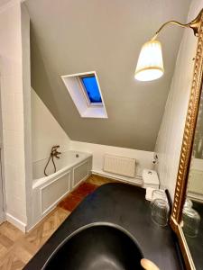 een badkamer met een zwarte wastafel en een raam bij Château le Withof in Bourbourg