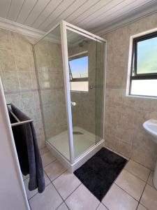 a bathroom with a shower and a sink at Hogsback Misty Oaks Cottage in Hogsback +38 photos