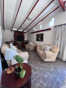 a large living room with couches and a fireplace at Hogsback Misty Oaks Cottage in Hogsback