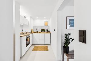 a white kitchen with white cabinets and a table at Stylischer Wohn(t)Raum am Markt in Wuppertal