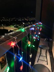 a balcony decorated with christmas lights at night at Paradise Apartment in San Salvador