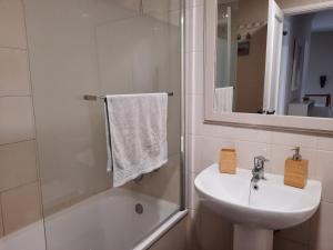 La salle de bains blanche est pourvue d'un lavabo et d'une douche. dans l'établissement Casa La Buena Ola, à Playa del Hombre