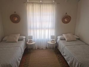 2 aparte bedden in een kamer met 2 tafels bij Casa La Buena Ola in Playa del Hombre