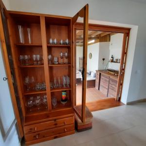a wooden cabinet with glasses in a kitchen at Casa La Buena Ola in Playa del Hombre