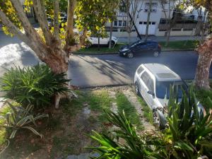 una furgoneta blanca estacionada al lado de una calle en Aparts del Jardin en Tigre