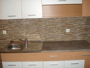 a kitchen with a sink and wooden cabinets at Apartments & Rooms Bojic in Kolašin +60 photos