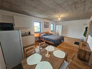a room with a bed and a table and a kitchen at Hoch2 Apartment - Modern, komfortabel & 24h Self-Check-in mit Parkplatz in Mattighofen