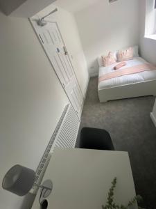 a room with a desk and a bed and a chair at Erin Guest House in Bristol