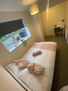 een slaapkamer met een bed met 2 kussens en een raam bij Erin Guest House in Bristol