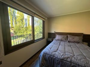 1 dormitorio con cama y ventana grande en mirabosque aparment ejecutivo 5 en Osorno