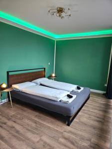 a bedroom with a bed with a green wall at Sweet Home - 1 - in Moers