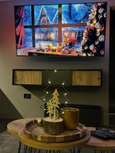 a table with a christmas tree in front of a tv at Beta Lux in Zaječar