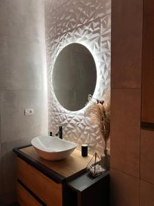 een badkamer met een wastafel en een spiegel bij Bright & Modern 3 Room Apartment with All Amenities and Underground parking in Timişoara