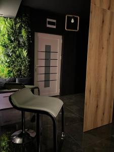 una silla verde en una habitación con plantas en Beta Lux en Zaječar