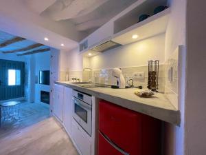 a kitchen with white cabinets and a red drawer at CASA MÚA in Frigiliana