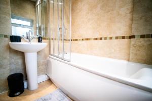 a bathroom with a sink and a bath tub at Stay with Serena Homes , One bedroom apartment in Purley